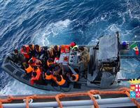 Спасатели перевозят на катере группу мигрантов