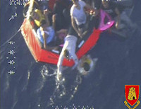 Упавших в воду пытаются выловить и затащить в лодку