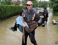 Мужчина несет на руках спасенную старушку