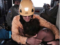 Спасатель обнимает плачущую колумбийку