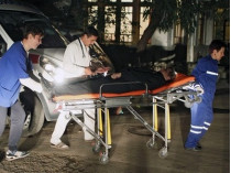 Медики оказывают помощь пострадавшим в автокатастрофе