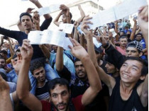 Беженцы с билетами перед вокзалом Келети