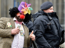 Клоун стоит рядом с полицейским в Кельне