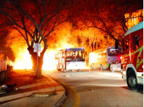 Горящие после взрыва автобус и автомобиль