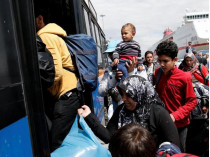 Мигрантов сажают в автобусы в порту Пирей