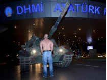 Человек стоит перед танком