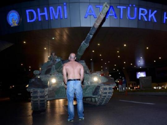 Человек стоит перед танком