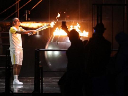 Бывший бразильский марафонец Вандерлей де Лима зажигает чашу с олимпийским огнем