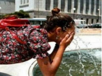 Девушка умывается водой из фонтана