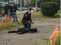Полицейский склонился над нападавшим