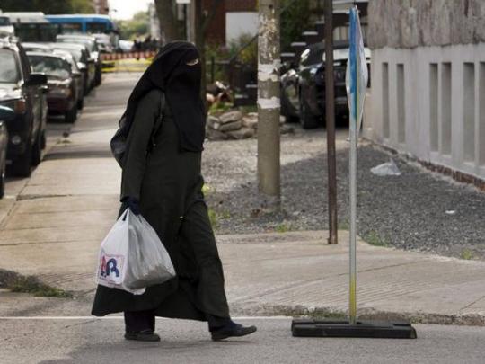 Женщина идет по улице в никабе
