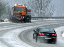 Снегоуборочная машина и автомобиль на заснеженной дороге