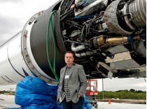 Илон Маск на фоне ракеты Falcon