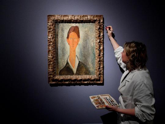 Посетитель выставки рассматривает картину Модильяни