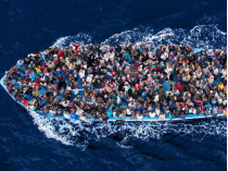 Переполненная лодка с мигрантами