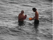 Дедушка и отец выносят новорожденного на берег