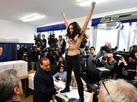 В Италии полуобнаженная активистка Femen разделась перед Берлускони, когда он голосовал