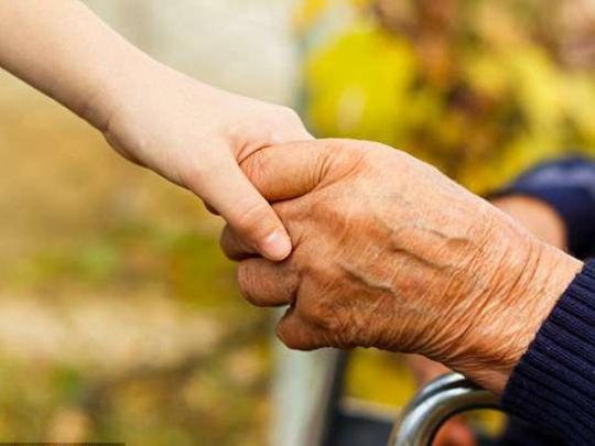 Рука пожилого человека держдит детскую руку 