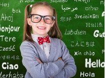 Девочка на фоне классной доски со словами на разных языках