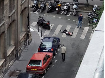 Человек лежит на улице в центре Парижа