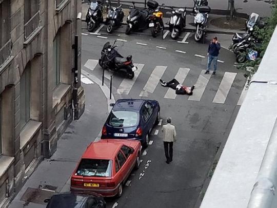 Человек лежит на улице в центре Парижа