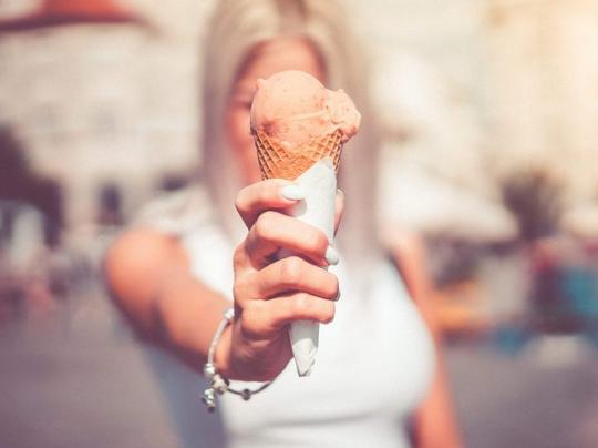 Женщина держит мороженое