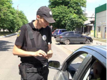 полицейский проверяет права у водителя