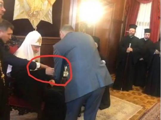Руку патриарха Кирилла направляют к конкретному стакану 