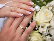 Руки жениха и невесты с обручальными кольцами
