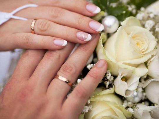 Руки жениха и невесты с обручальными кольцами