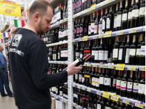 Человек в супермаркете выбирает алкоголь 
