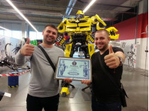 Дмитрий Мицык и Сергей Еременко (слева) с дипломом о регистрации рекорда на фоне самого любимого детьми робота Бамблби