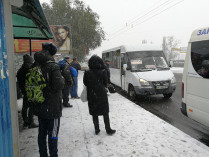 Люди на остановке общественного транспорта в снегопад