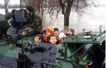 Военные на бронетранспортерах эвакуируют людей, которых наводнение застало врасплох