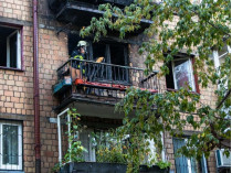 спасатель на балконе сгоревшей квартиры