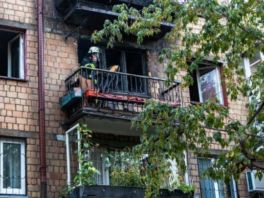 спасатель на балконе сгоревшей квартиры
