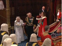 Королева и принц Чарльз входят в зал
