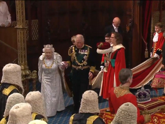 Королева и принц Чарльз входят в зал