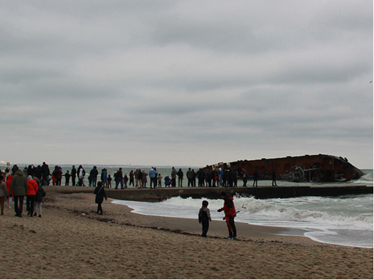 Люди на пляже&nbsp;— танкер у берега 