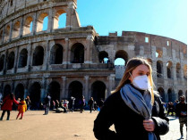 Девушка в медицинской маске на фоне Колизея