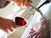 Вино льется из крана в бокал