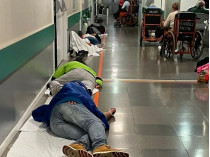 Люди лежат в коридорах больницы