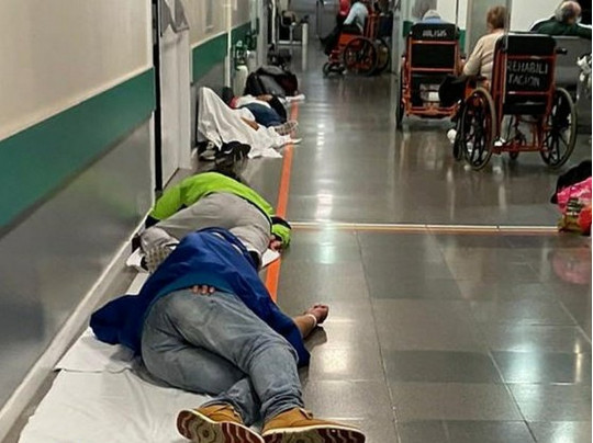 Люди лежат в коридорах больницы