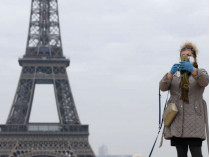 Женщина в маске на фоне Эйфелевой башни