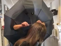 Парикмахер стрижет клиентку через зонтик