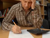Человек с бумагами, ручкой и калькулятором