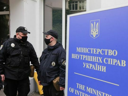 Поліцейські поряд із вивіскою МВС