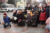 Люди стоять на колінах на похороні Тараса Козлишина