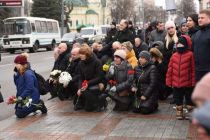 Люди стоят на коленях на похоронах Тараса Козлишина