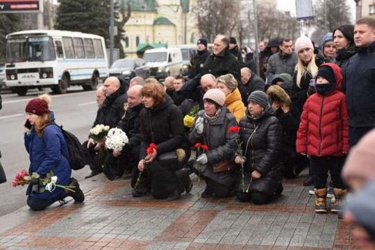 Люди стоять на колінах на похороні Тараса Козлишина